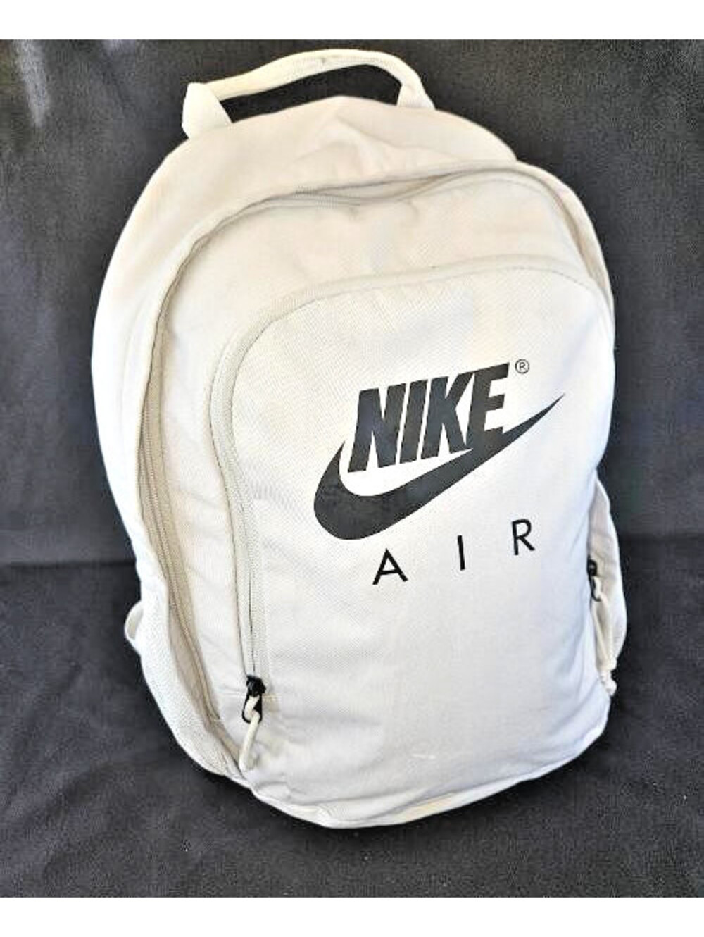 Nike Air light gray backpack with a prominent Nike Air logo on front pocket.